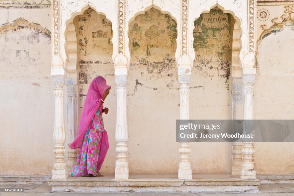 Woman in traditional Indian clothing walking under portico