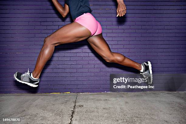 female athlete running on sidewalk - running legs ストックフォトと画像