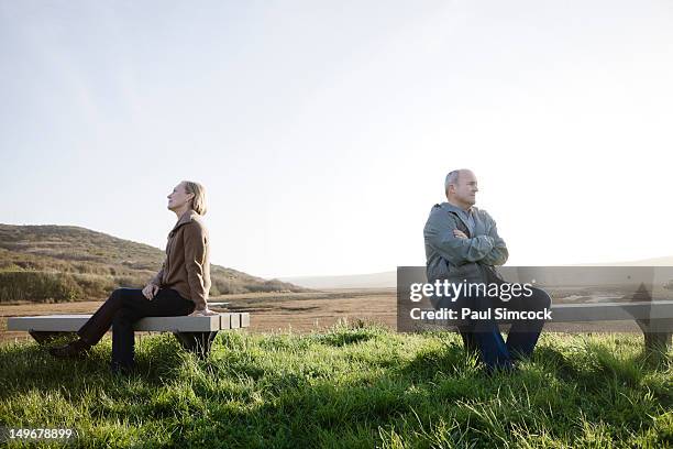 caucasian sitting back to back on benches at beach - couple ignore stock pictures, royalty-free photos & images