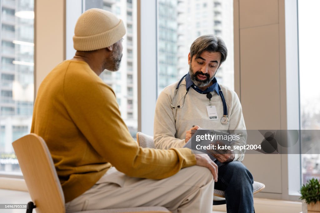 Aufnahme eines Arztes, der eine Konsultation mit einem Patienten in seinem Büro hat