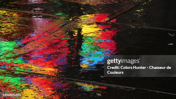 the colorful lights of times square advertising screens reflect in a puddle on a sidewalk in manhattan, new york state, united states - times square night stock pictures, royalty-free photos & images