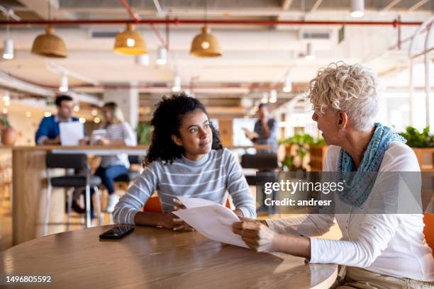 geschäftsfrau, die eine junge frau für einen job in einem coworking interviewt - bewerbungsformular stock-fotos und bilder