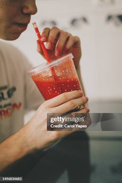 male drinking from  a reusable glass with berries smoothie - rietje stockfoto's en -beelden