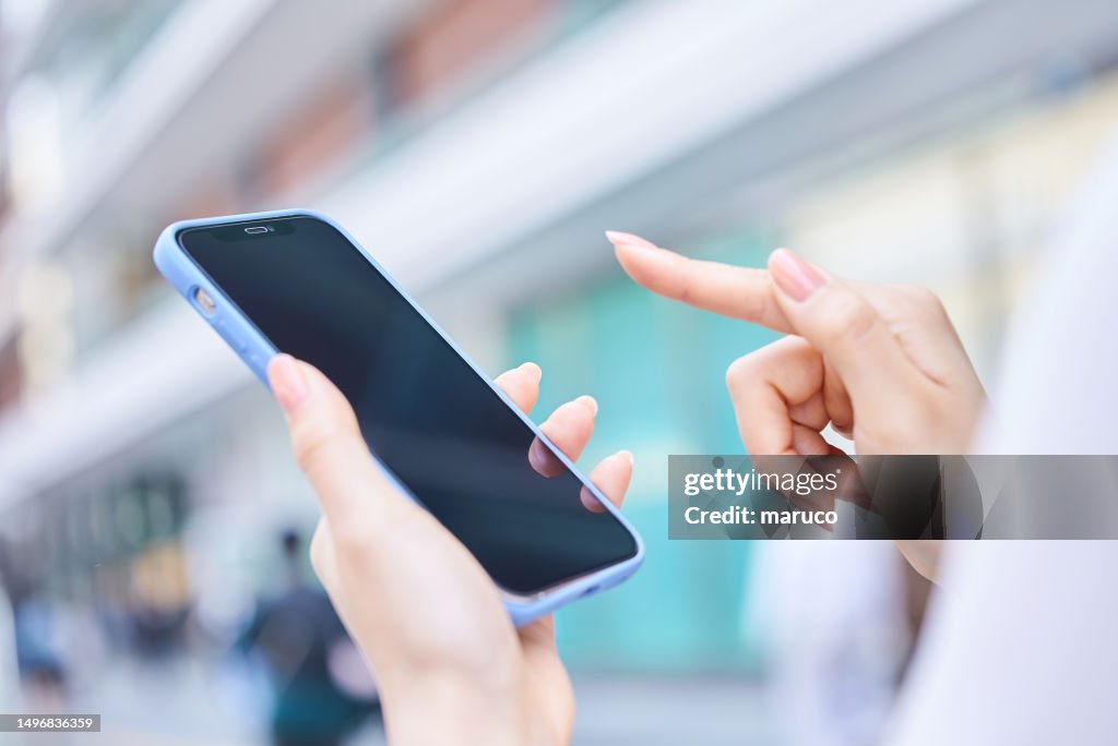 A woman using a smartphone on a street corner