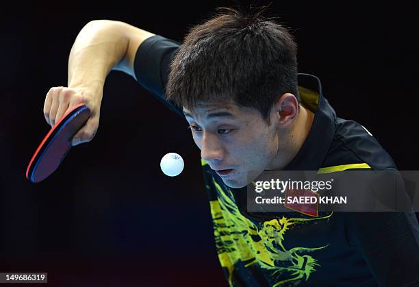 Zhang Jike of China watches the ball as he serves during his table tennis men's gold medal singles match against compatriot Wang Hao for the London...