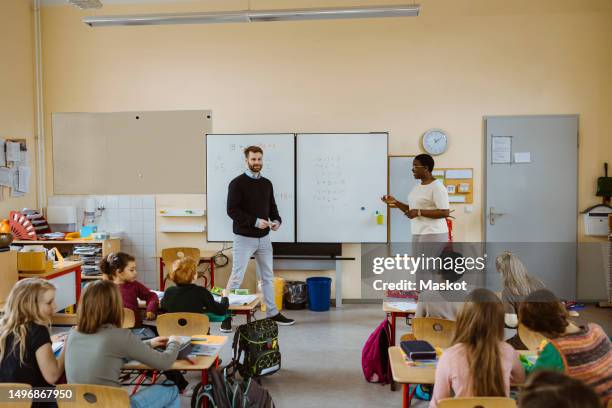 male and female teachers teaching mathematics to pupils in classroom - male teacher in a classroom stock-fotos und bilder