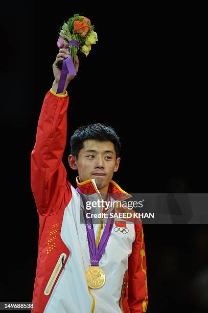 Gold medallist Zhang Jike of China waves after victory in his table tennis men's gold medal singles match against compatriot silver medallist Wang...