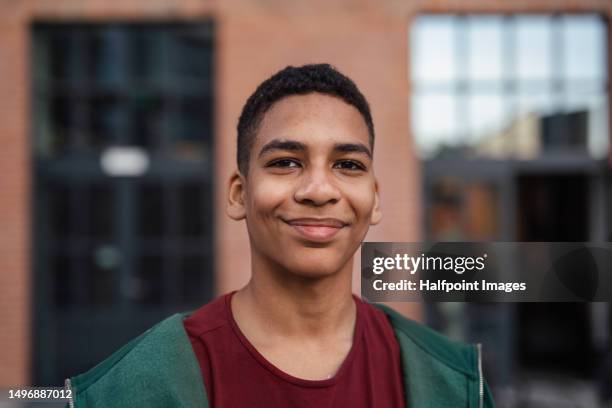 portrait of happy teenage boy posing in a city. - injured street stock-fotos und bilder