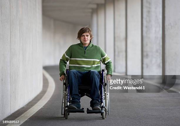 austria, mondsee, young man sitting on wheelchair at subway - mobility disability stock pictures, royalty-free photos & images