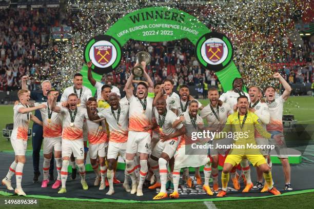 Declan Rice of West Ham United lifts the Winners' trophy as he celebrates with team mates on the podium following the UEFA Europa Conference League...