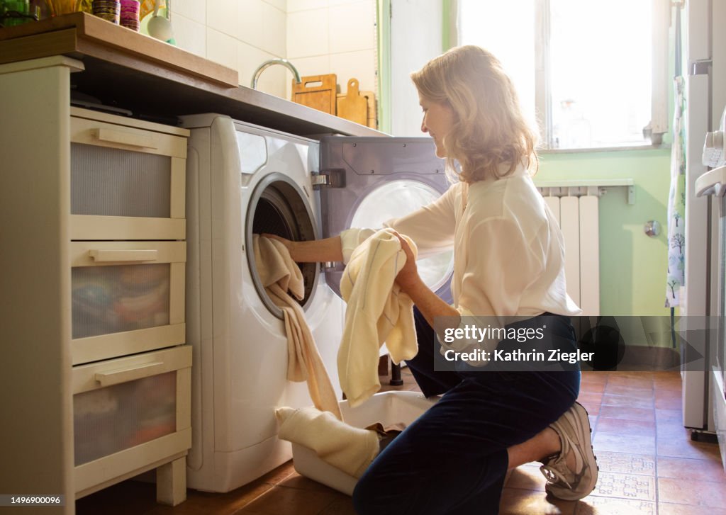 Woman putting cashmere sweaters in the washing machine