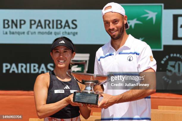 Miyu Kato of Japan and partner Tim Puetz of Germany lift the trophy after winning match point against Bianca Andreescu of Canada and Michael Venus of...