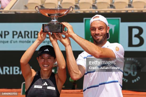 Miyu Kato of Japan and partner Tim Puetz of Germany lift the trophy after winning match point against Bianca Andreescu of Canada and Michael Venus of...