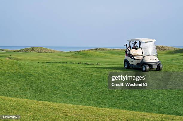 turkey, antalya, golf cart on meadow at golf course - golfplatz stock-fotos und bilder