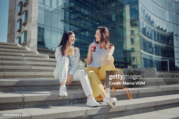 glücklich, freunde und smoothie mit frauen in der stadt für entspannung, sommergetränke und energie. gespräche, ernährung und bindung mit menschen auf stufen im freien für urban, glück und milchshake - athleisure stock-fotos und bilder