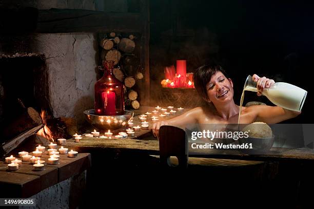 austria, salzburg county, young woman taking bath in wooden tub - woman bath tub wet hair stock pictures, royalty-free photos & images