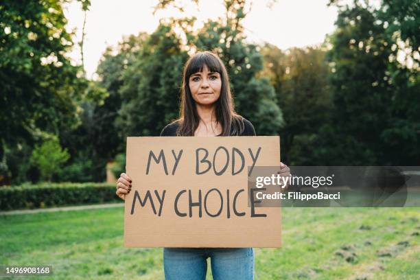 a woman is holding a cardboard with the text "my body my choice" - abortion symbol stock pictures, royalty-free photos & images