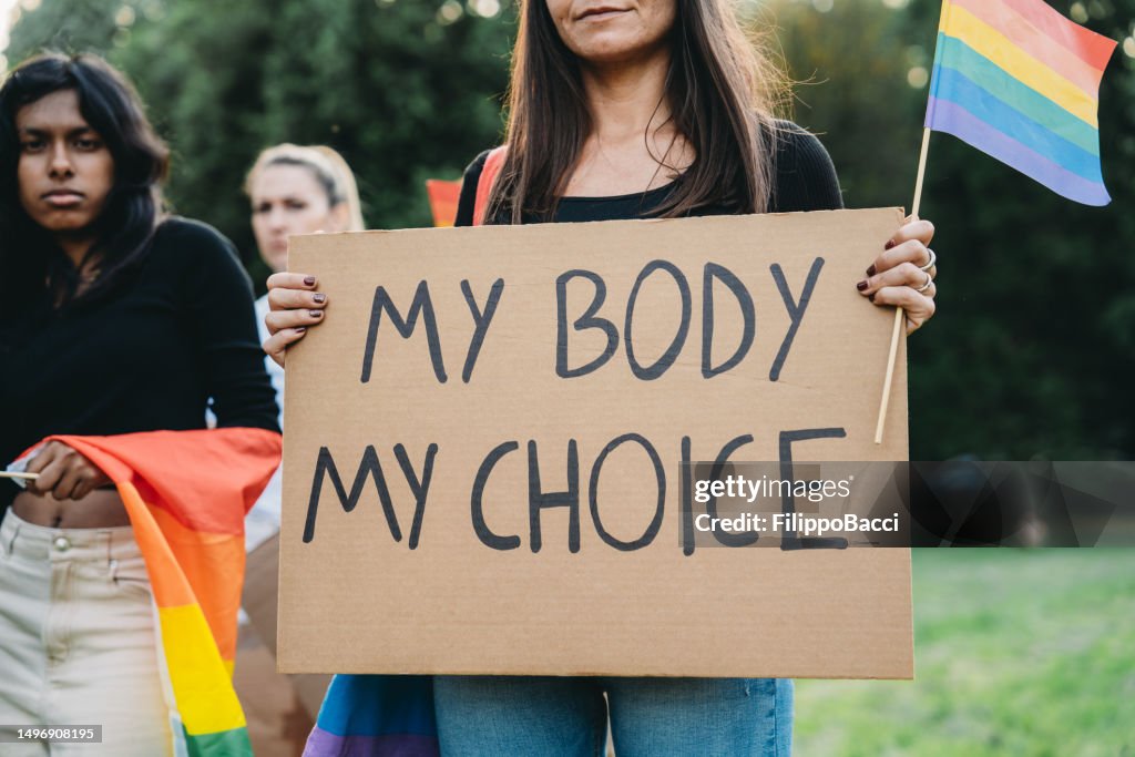 A woman is holding a cardboard with the text "My body my choice"