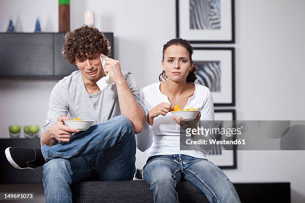 germany, bavaria, young couple watching tv - crying woman stock-fotos und bilder
