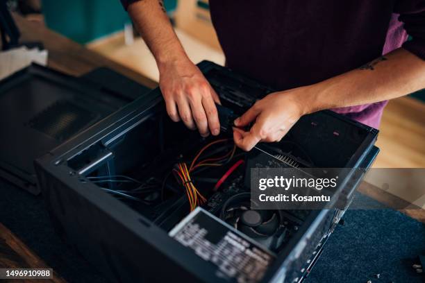 close-up of the hands of a man trying to fix a computer at home - dismantling stock pictures, royalty-free photos & images