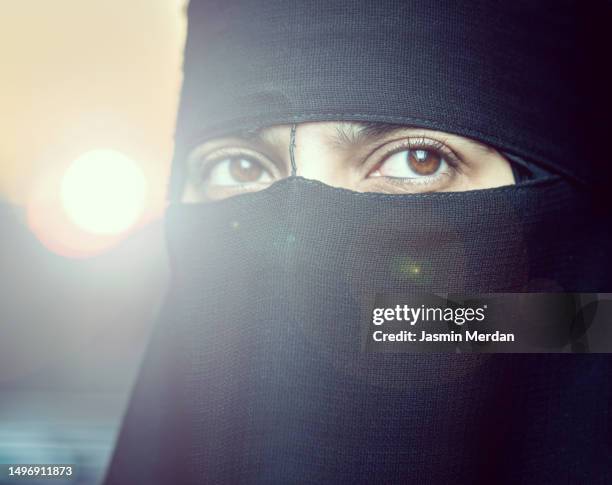 muslim woman on sunset lens flare - nikab stock-fotos und bilder