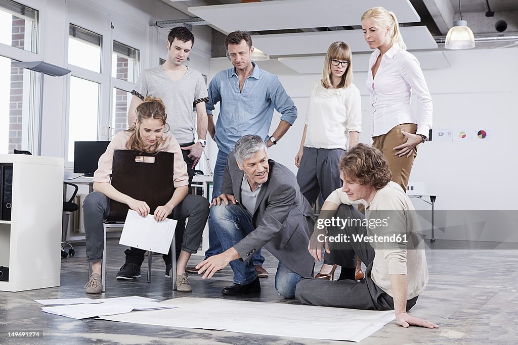 Germany, Bavaria, Munich, Men and women discussing in office