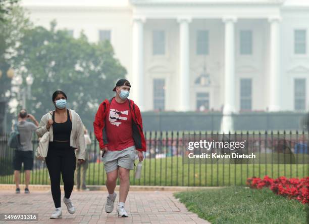 People wear masks as the White House is seen through hazy skies caused by Canadian wildfires on June 08, 2023 in Washington, DC The Washington DC...