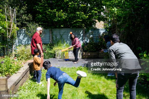 multi-generation cricket play in back garden - family cricket stockfoto's en -beelden