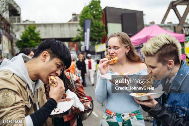 giovani amici che si godono il cibo di strada dell'east end per pranzo - tower hamlets foto e immagini stock