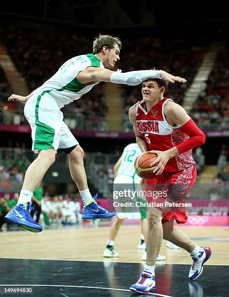 Timofey Mozgov of Russia receives an arm to the head as he looks to shoot against Tiago Splitter of Brazil in the second half during the Men's...