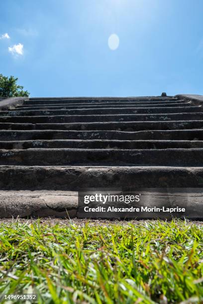 steps of mayan pyramid in tazumal site with green grass and blue sky with flare - alexandre stock pictures, royalty-free photos & images