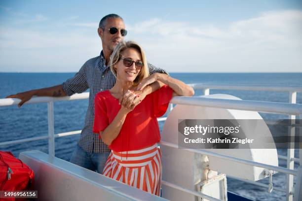 happy couple embracing  on deck of a ferry - couple traveler stock pictures, royalty-free photos & images