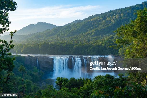 scenic view of waterfall in forest against sky,chalakudy,kerala,india - kerala waterfall stock pictures, royalty-free photos & images