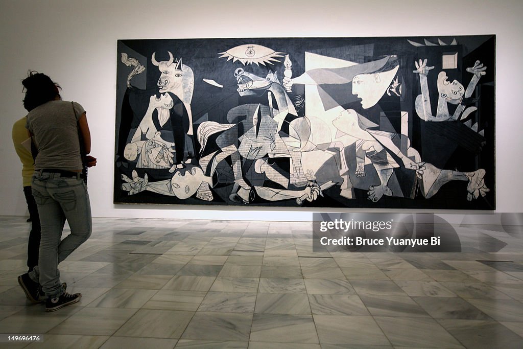 Visitors looking at Pablo Picasso's Guernica in Reina Sofia National Art Museum (Museo Nacional de Arte Reina Sofia).