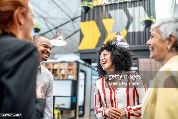 happy coworkers talking at office - making connections stock pictures, royalty-free photos & images