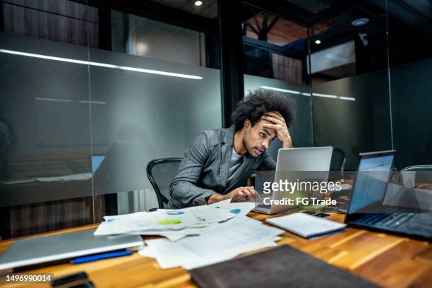 worried businessman working using laptop at office - overworked stock pictures, royalty-free photos & images