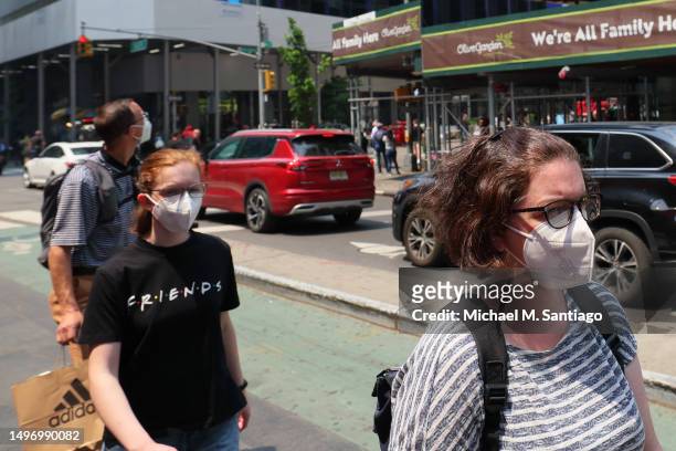 People wear masks amid hazy conditions due to smoke from the Canadian wildfires in Times Square on June 08, 2023 in New York City. People in the city...