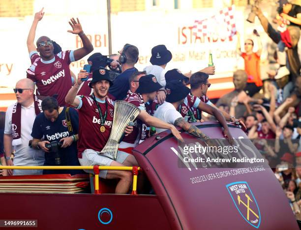 Declan Rice of West Ham United celebrates with the Europa Conference League trophy as players of West Ham United pass through a crowd of fans during...
