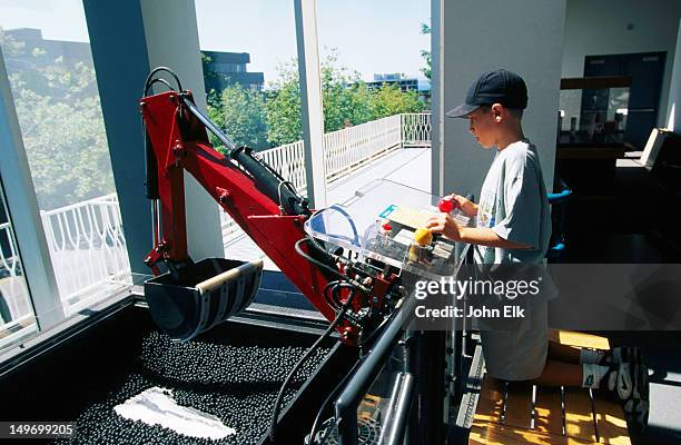 boy on interactive exhibit at pacific science center at seattle center. - pacific science center seattle stock pictures, royalty-free photos & images