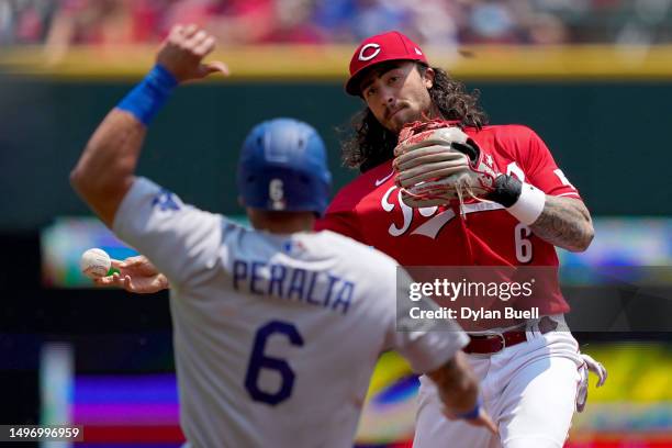 Jonathan India of the Cincinnati Reds turns a double play past David Peralta of the Los Angeles Dodgers in the first inning at Great American Ball...