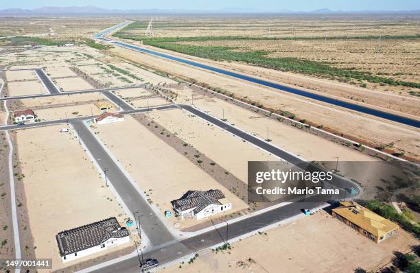 In an aerial view, new homes are seen under construction at a housing development, near the Central Arizona Project canal running through the Sonoran...