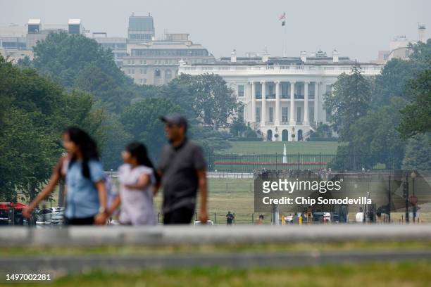 Wildfire smoke puts a veil of haze in front of the White House as tourists walk along the National Mall on June 08, 2023 in Washington, DC. Air...
