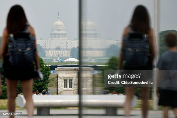 Wildfire smoke puts a veil of haze in front of the U.S. Capitol as tourists walk along the National Mall on June 08, 2023 in Washington, DC. Air...