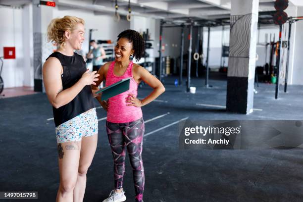 coach welcoming a new woman in the gym - gym coach stock pictures, royalty-free photos & images