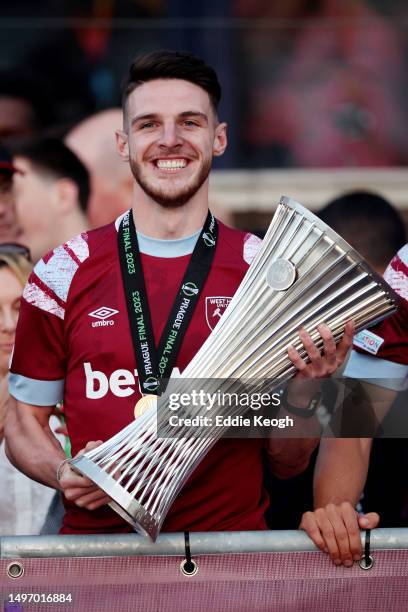 Declan Rice of West Ham United poses for a photograph with the Europa Conference League trophy as players of West Ham United celebrate in front of a...