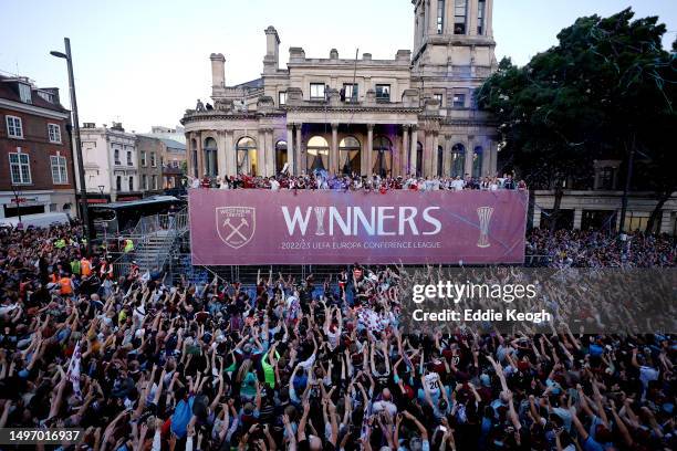 General view as players of West Ham United celebrate with the Europa Conference League trophy on a balcony whilst looking out over a crowd of fans...