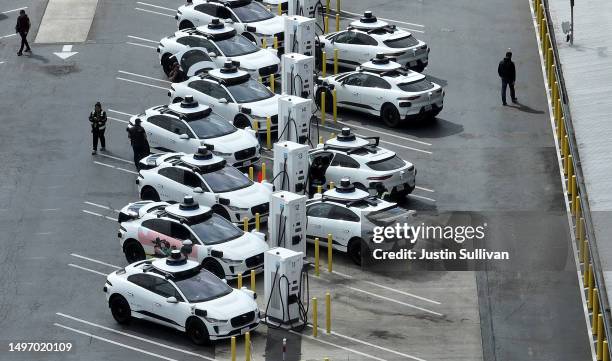 In an aerial view, Waymo autonomous vehicles sit parked in a staging area on June 08, 2023 in San Francisco, California. Autonomous vehicle companies...