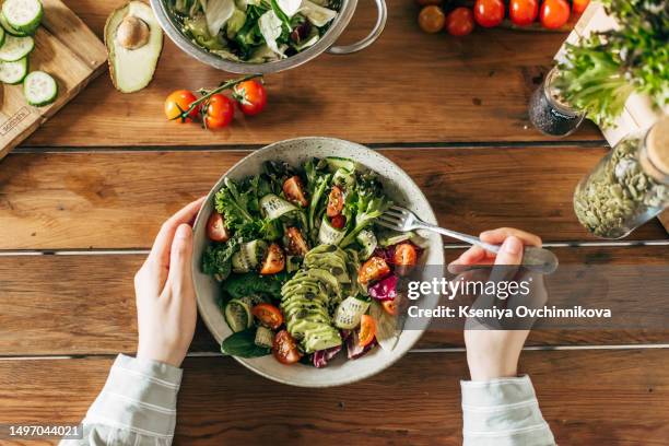 woman hands holding fresh summer salad with raw vegetables cabbage, spinach, radish, parsley, greens in bowl for dinner or lunch. vegan vegetarian healthy food. - verdura in foglia foto e immagini stock