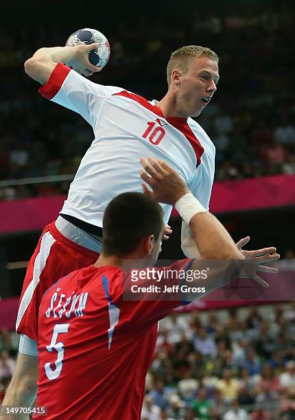 Nikolaj Markussen of Denmark shoots and scores over Zarko Sesum of Serbia in the Men's Preliminaries Group B match between Serbia and Denmark on Day...