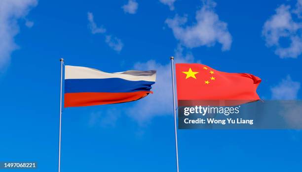 russia china flag with blue sky background - russische kultur stock-fotos und bilder